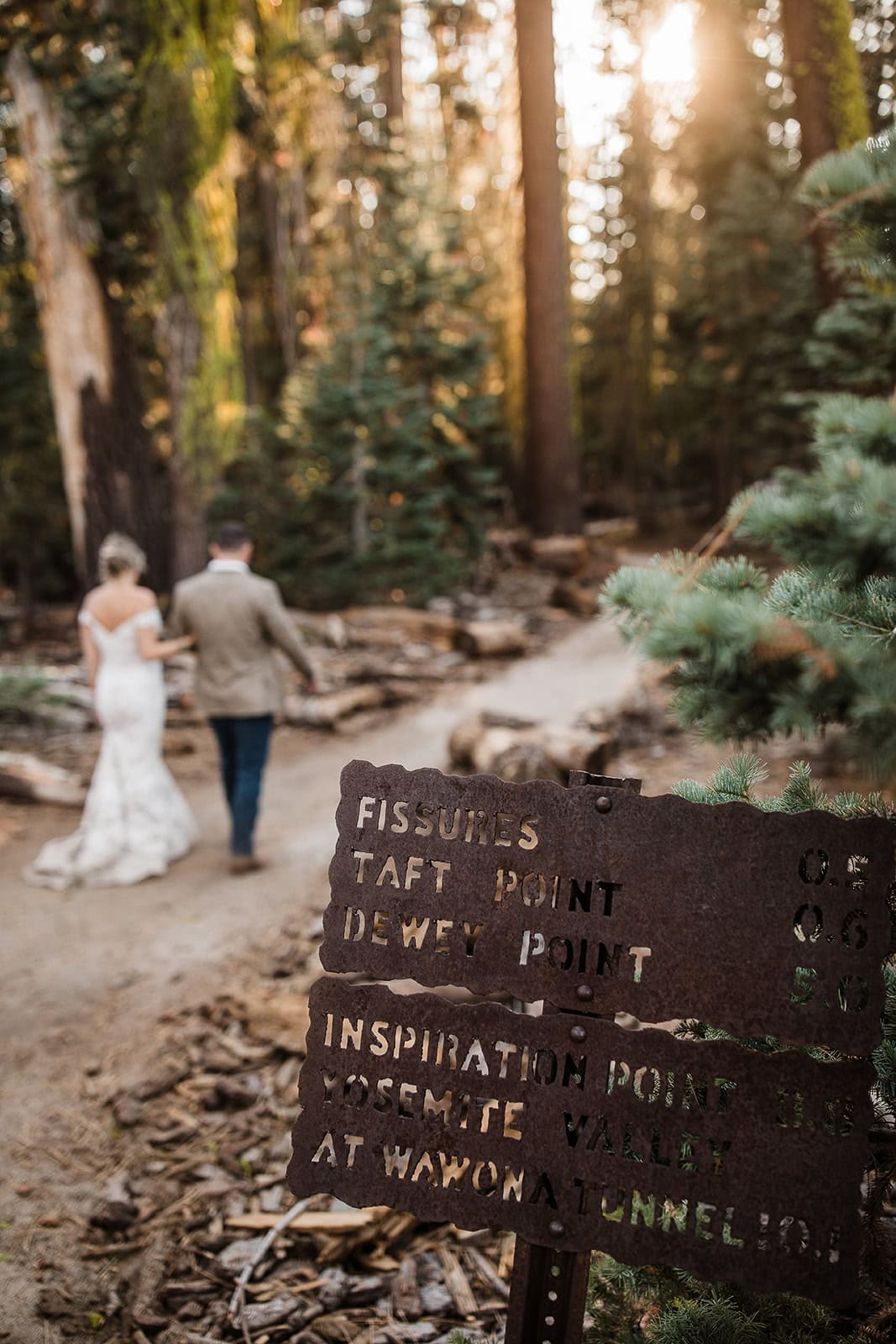 newlyweds hiking along a trail in Yosemite to Taft Point.