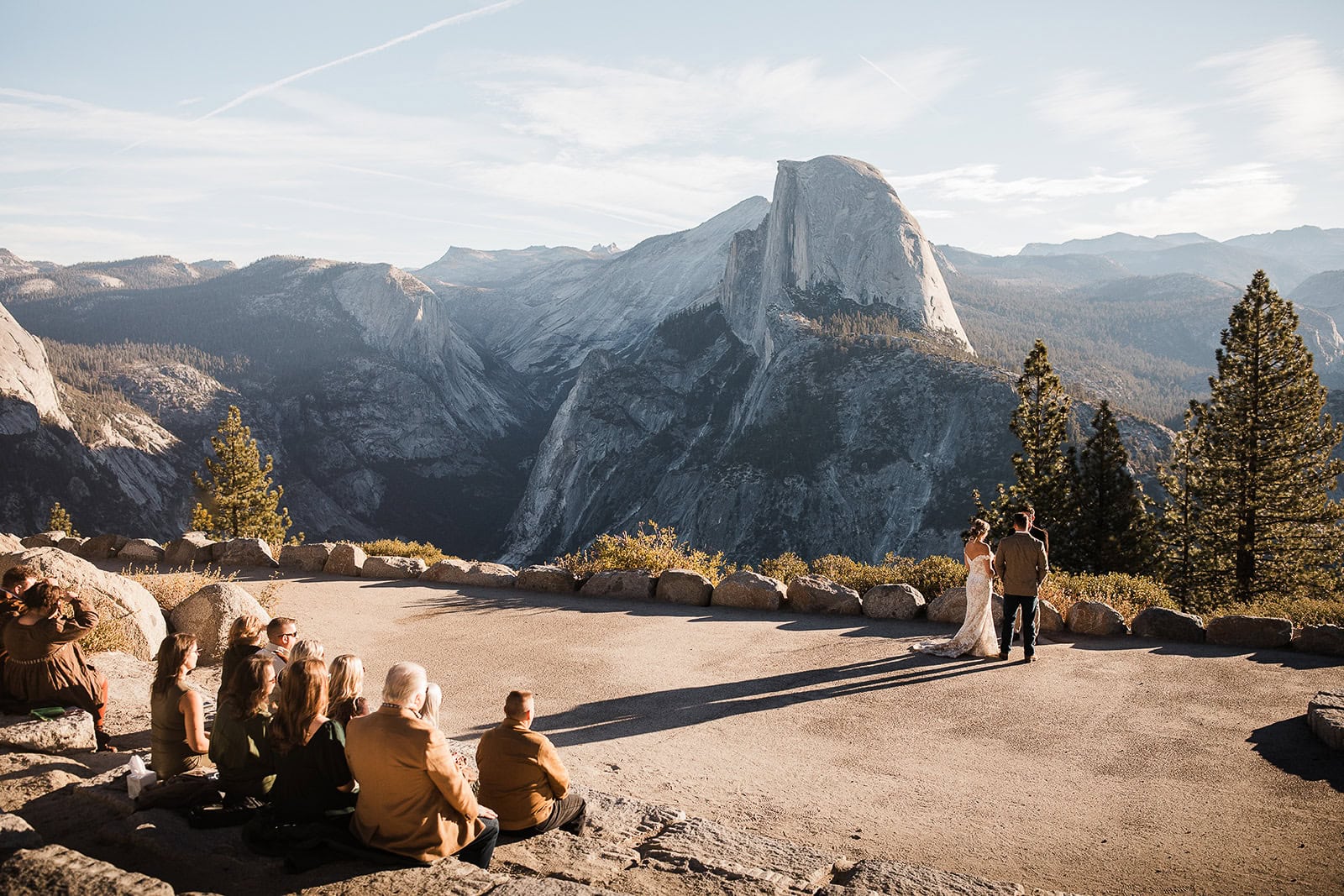 newlyweds during their wedding ceremony at glacier point with their family looking on.