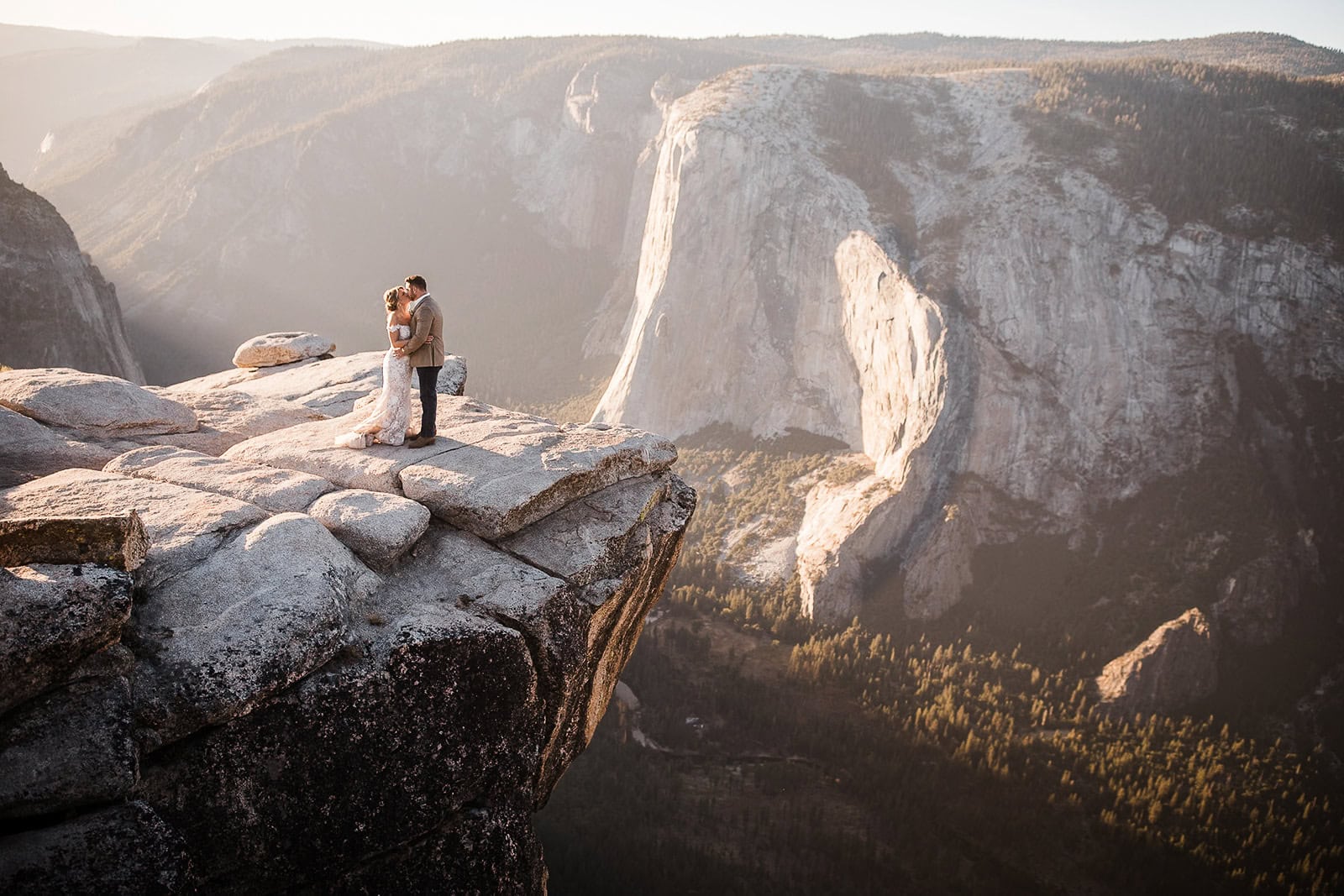 Newlyweds kissing at taft point, one of the best Yosemite wedding locations.