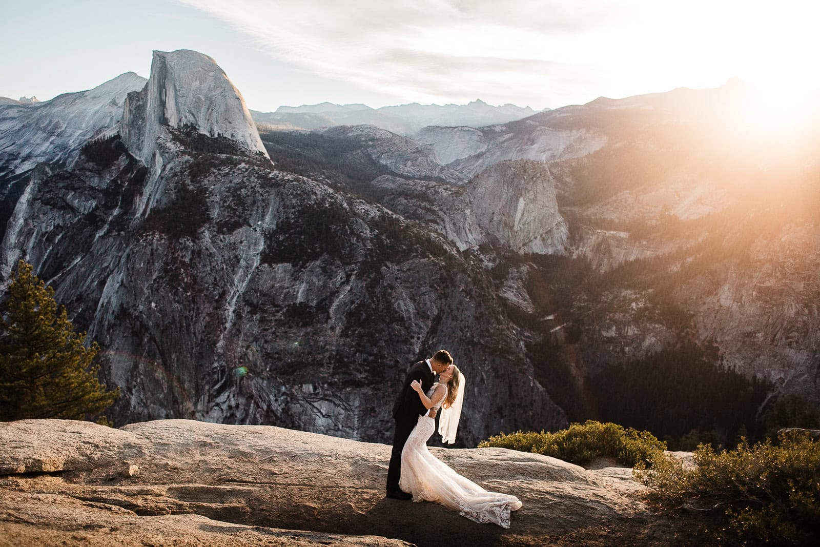 Newlyweds kissing at Glacier Point, one of the best Yosemite wedding locations.