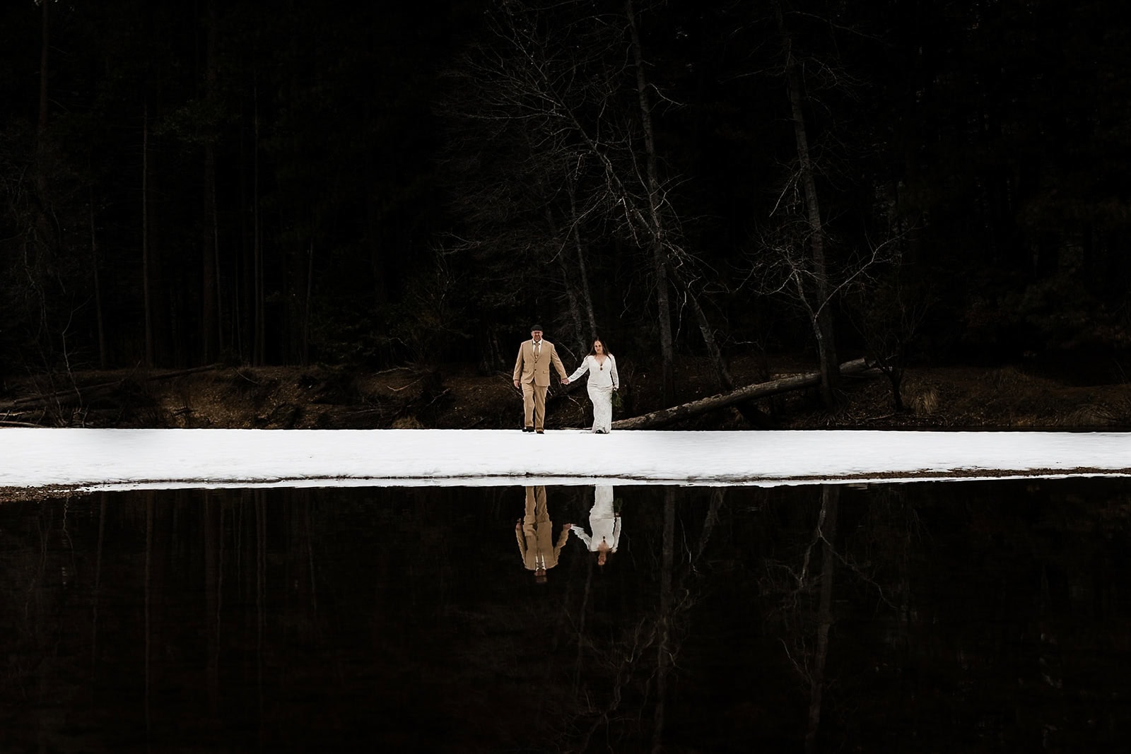 Newlyweds walking on the Yosemite Valley floor during the winter.