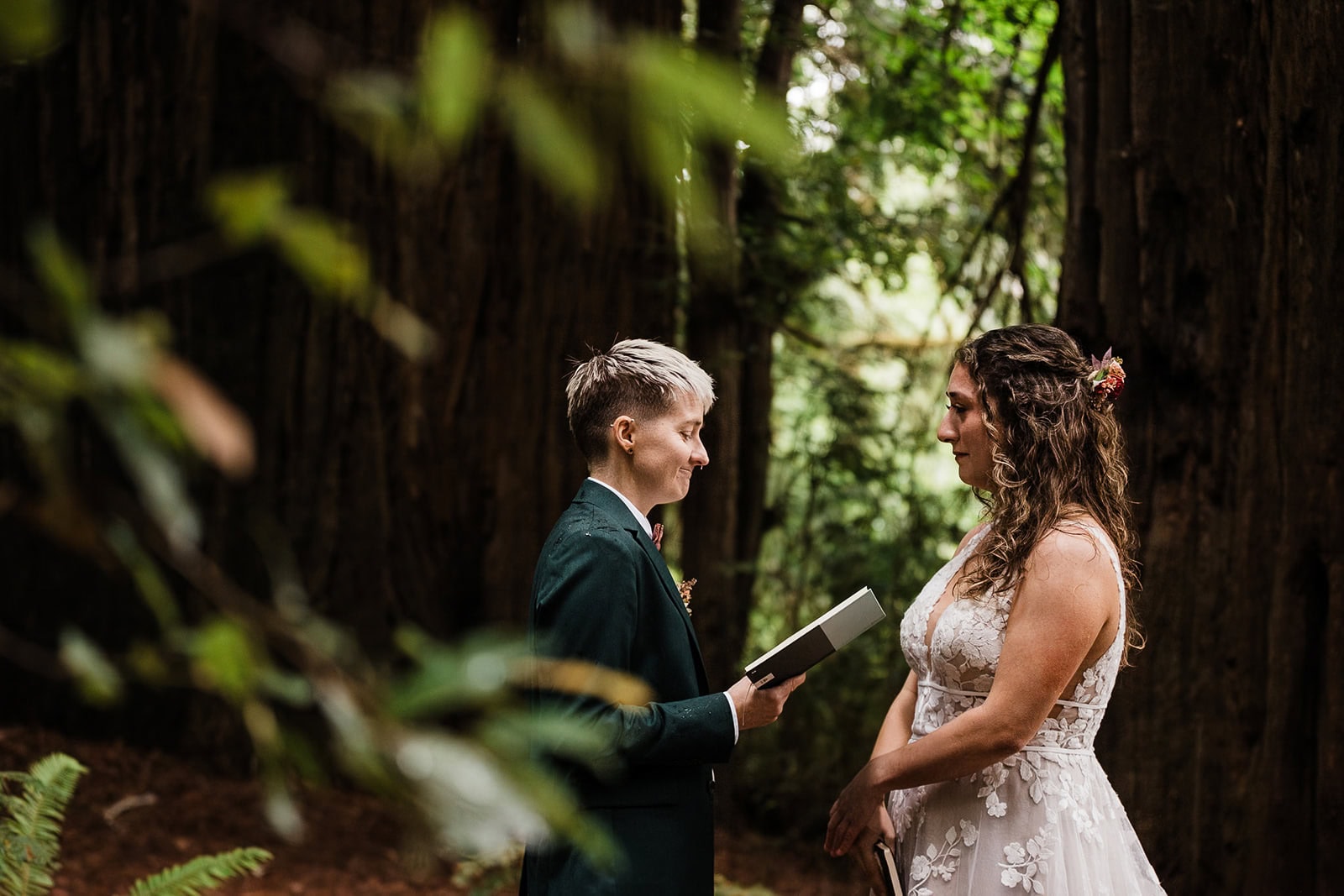 Newlyweds exchanging vows in a lush forest.