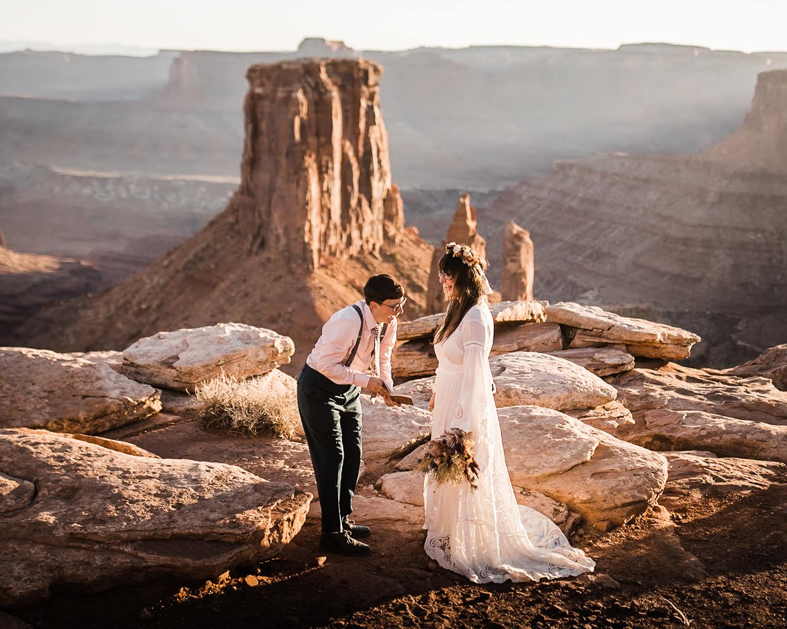 Newlyweds exchanging vows at the edge of a canyon.