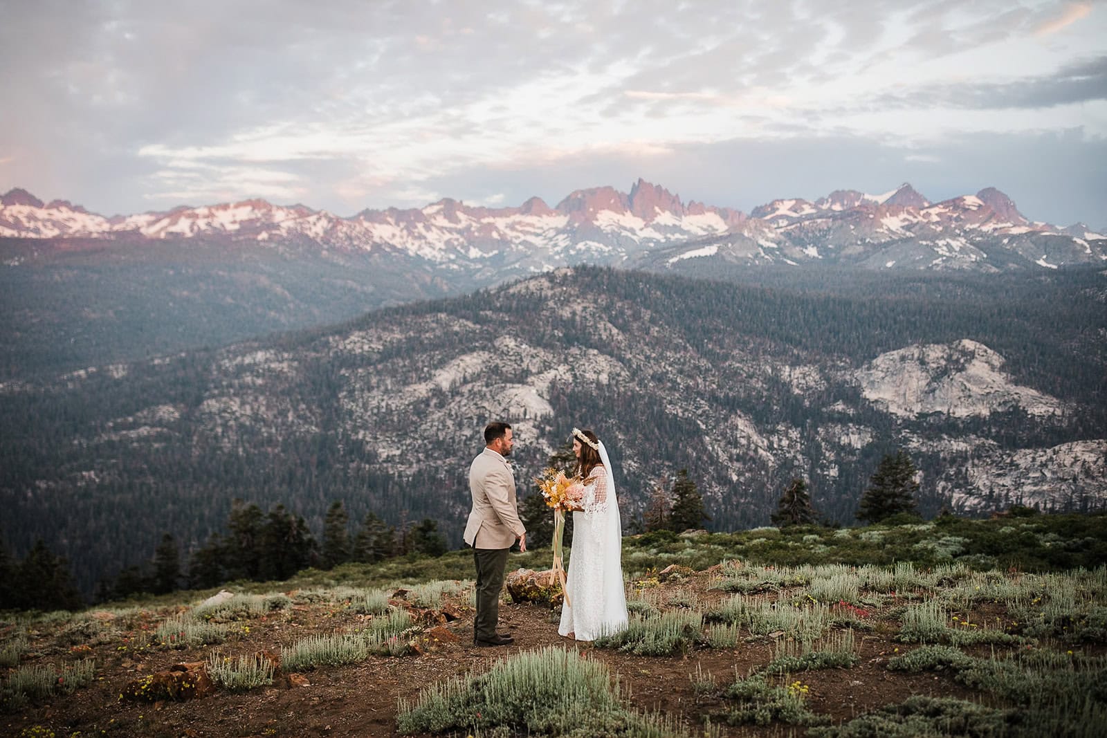 Newlyweds during their elopement ceremony in the mountains at sunrise.